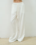 Close-up of the white Sunday Trousers, elasticated waistband and drawstring tie